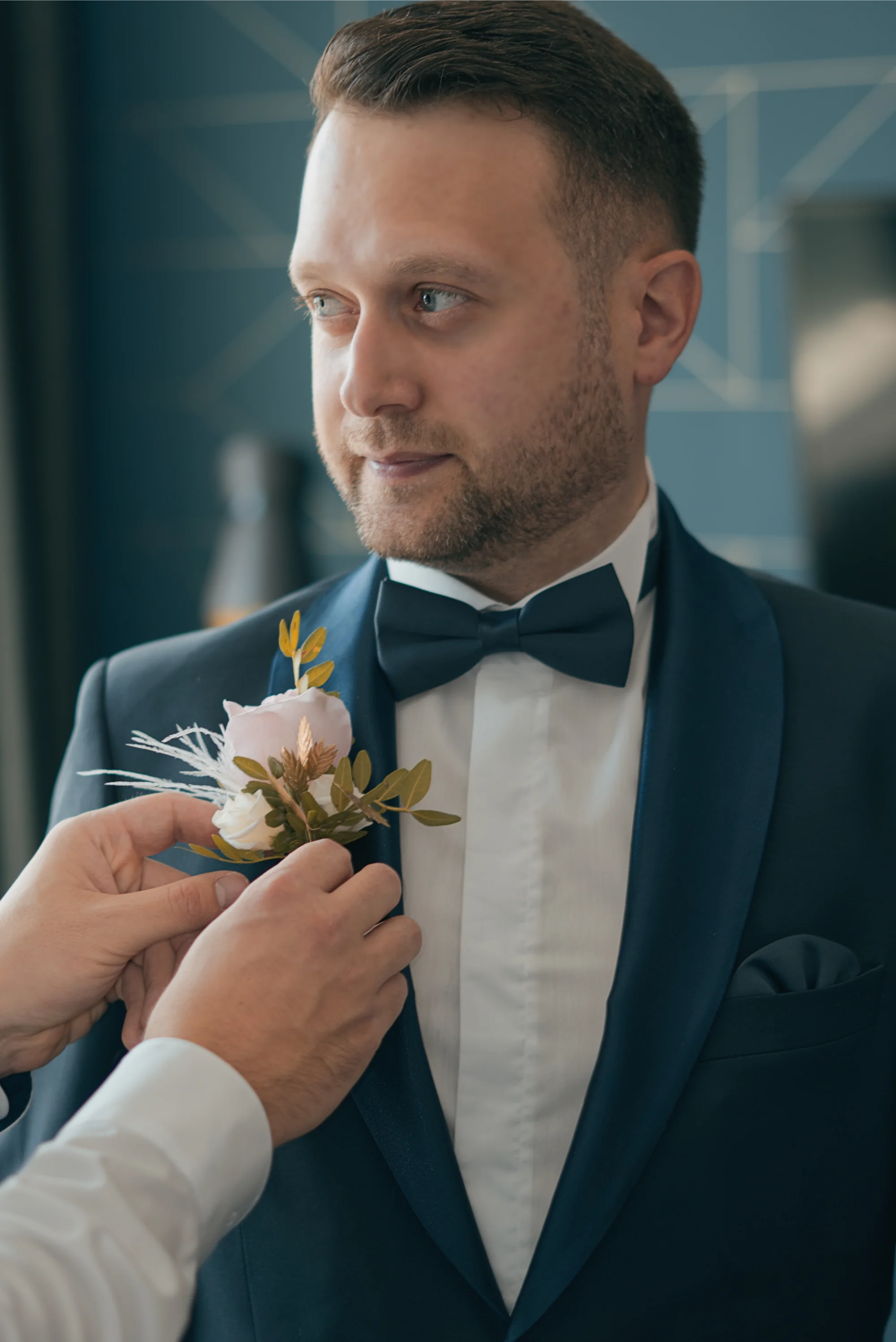 Getting Ready in Panoramahotel Waldenburg. Dem Bräutigam wird eine Blume auf Jacket befestigt.