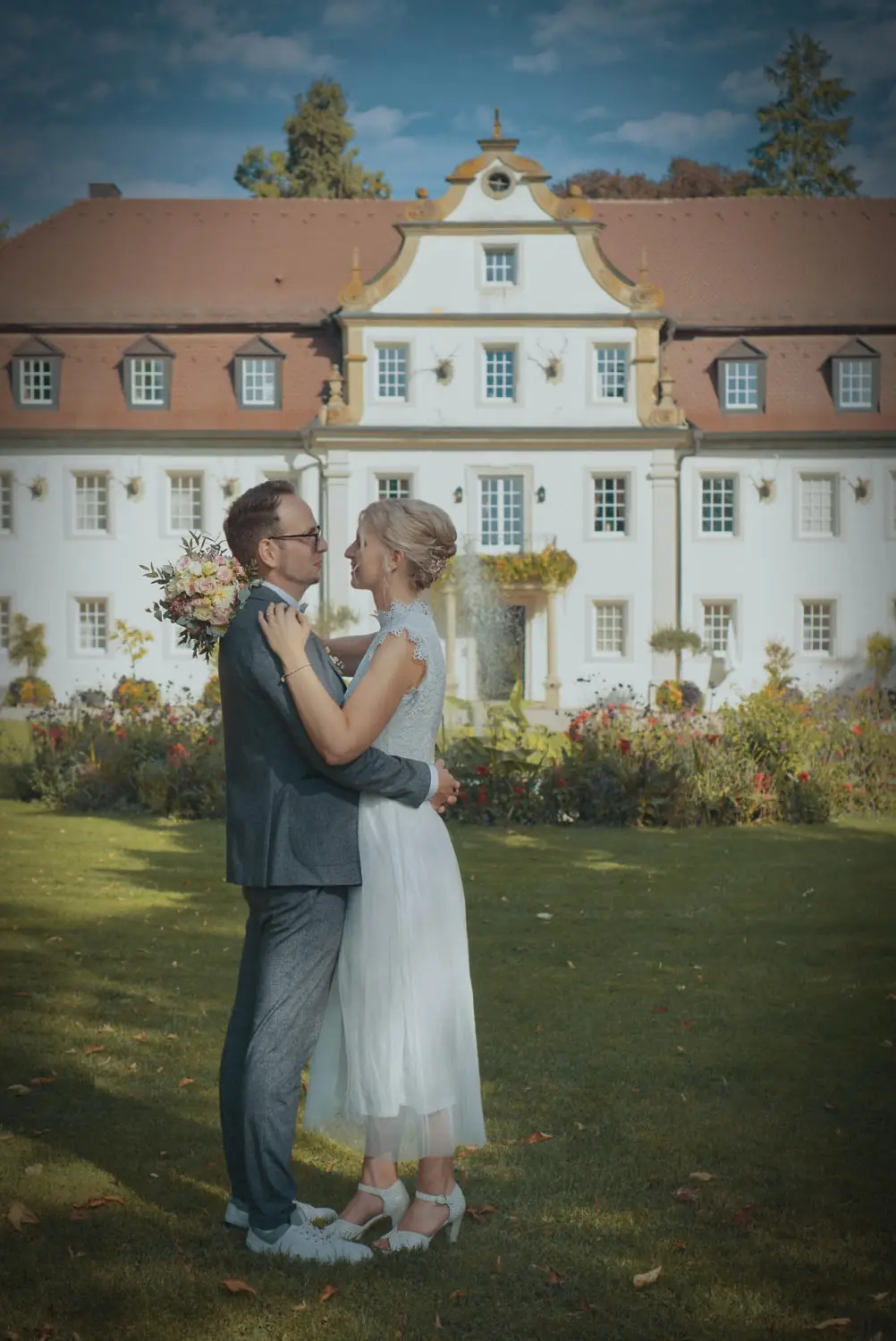 Schönes Foto mit dem Brautpaar vor Schlosshotel Friedrichsruhe